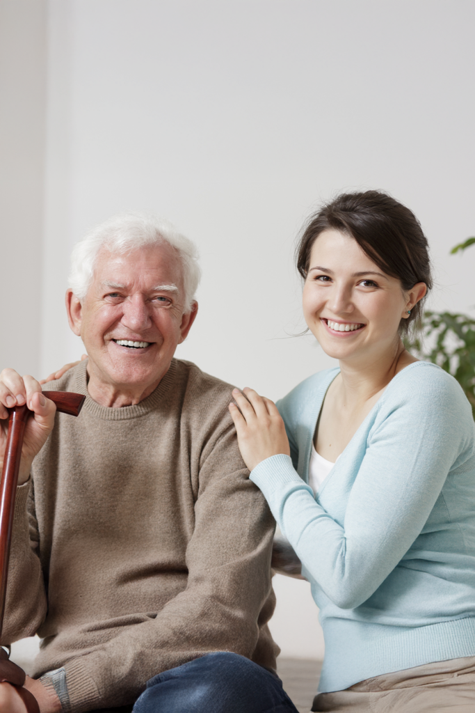 Elderly father and young daughter smiling at camera